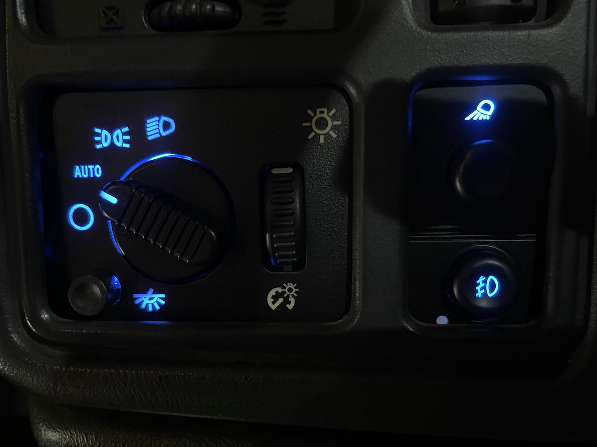 Blue LED headlight switch with AUTO setting and blue fog light switch lit up in a 2003-2006 GM truck dash
