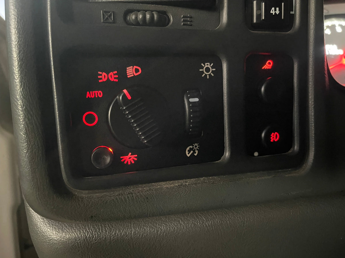 Red LED headlight and fog light switches lit up in a 2003-2006 Silverado dash